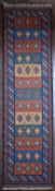 A Kashkai Kilim runner with repeating diamond motifs on sand, blue and burgundy bands within