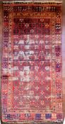 An antique Tabat carpet with repeating gul motifs across the deep red field contained within a