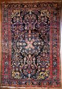 A Persian Hamadan rug with central floral medallion on midnight ground within stylised floral