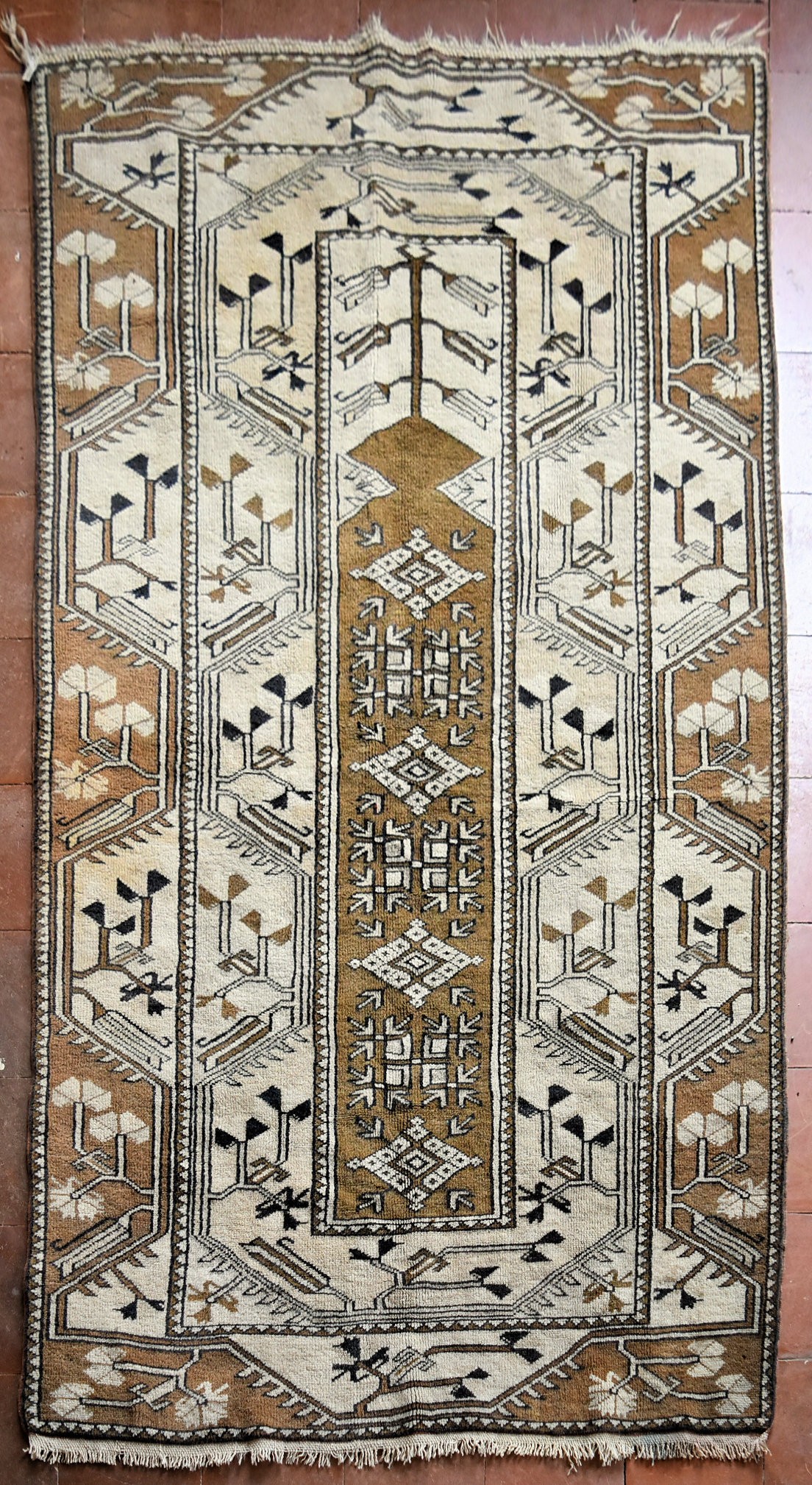 A Turkish Milas rug with central panel on fawn ground with stylised foliate design within