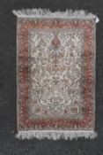 a Persian style silk prayer rug with scrolling floral design on a fawn field within bird and