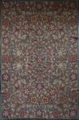 A needlepoint carpet with all over naturalistic flowerhead and leaf design within a wide floral