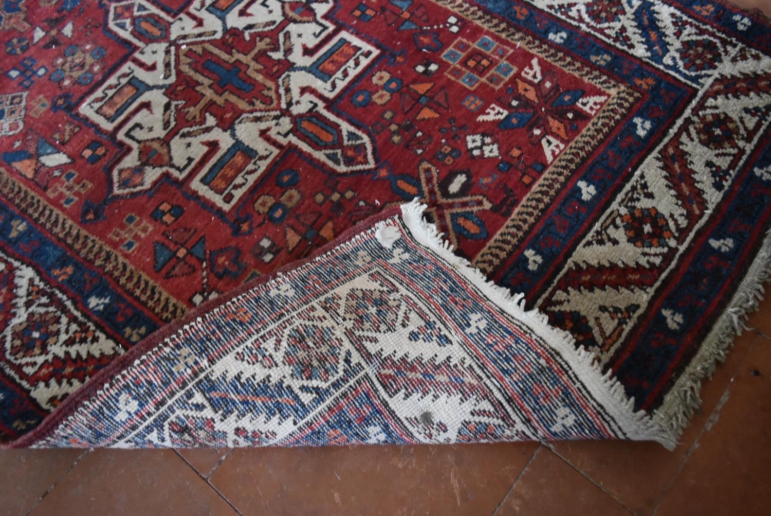 An antique Persian Heriz runner with repeating star medallions on a madder ground enclosed by - Image 4 of 4