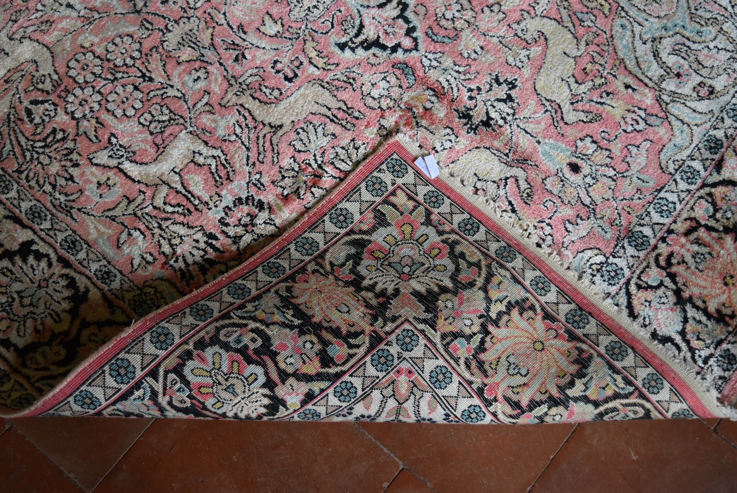 a Kashmir silk rug with floral medallion and spandrels on a salmon ground depicting animals in a - Image 4 of 4