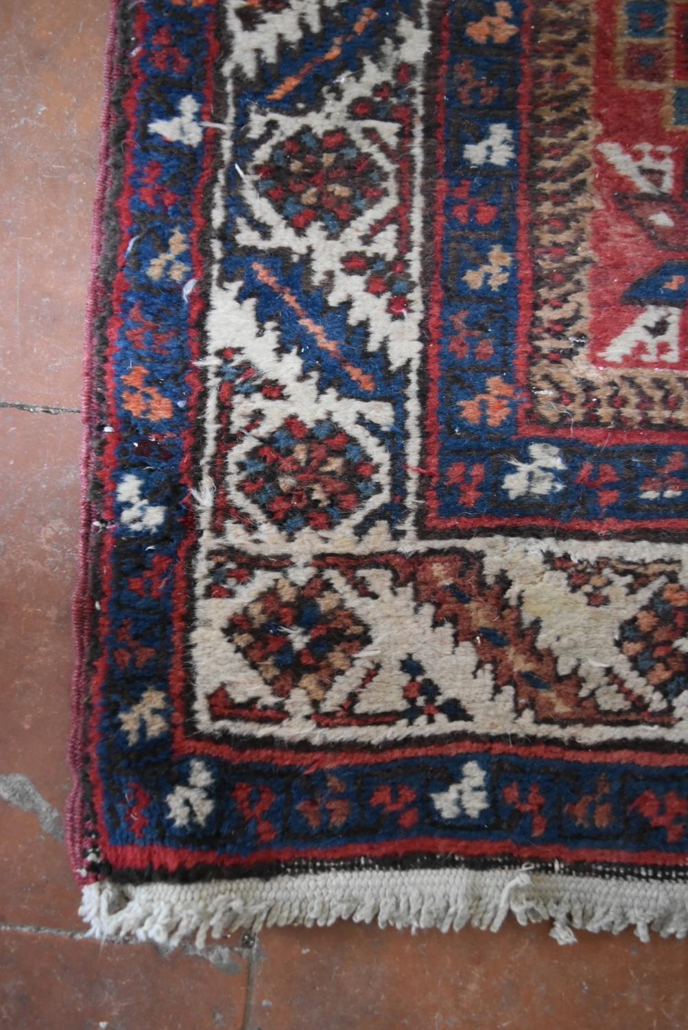 An antique Persian Heriz runner with repeating star medallions on a madder ground enclosed by - Image 3 of 4