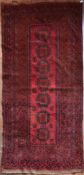 An antique Afghan rug with repeating floral medallions on burgundy field contained by multiple