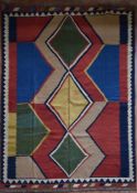 A Persian Kashkai Kilim with central diamond medallions in bold polychrome within geometric triple