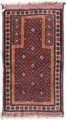 An Afghan Balouch prayer rug with repeating lozenge design within flowerhead border. L.160xW.85cm