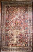 An antique Persian Mahal carpet with repeating lotus flower decoration across the madder ground