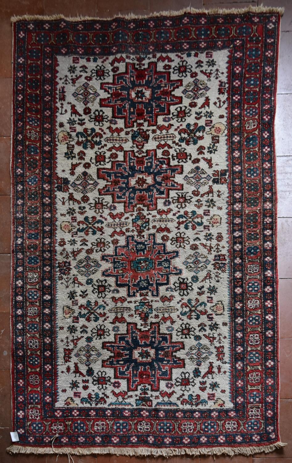 A Turkish Rug with repeating central medallions on ivory ground within stylised floral multi