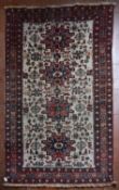 A Turkish Rug with repeating central medallions on ivory ground within stylised floral multi