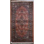 A silk Kashmir rug with central pendant medallion on madder field contained within floral
