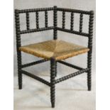 A late 19th century ebonised bobbin turned corner chair with woven rush seat on stretchered