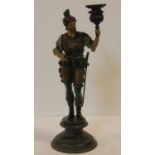 A painted spelter candle holder in the form of an armoured knight, with gilded and hand painted