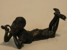 A Bergman style bronze of a boy lying on his stomach smoking a pipe. Stamped with Bergman mark, B in