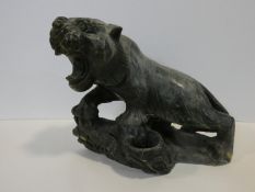 A Chinese carved greenstone figure of a prowling growling tiger on a naturalistic base. H.31xW.35cm