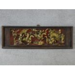 An antique Chinese carved lacquered and gilded panel with red round and warriors on horseback