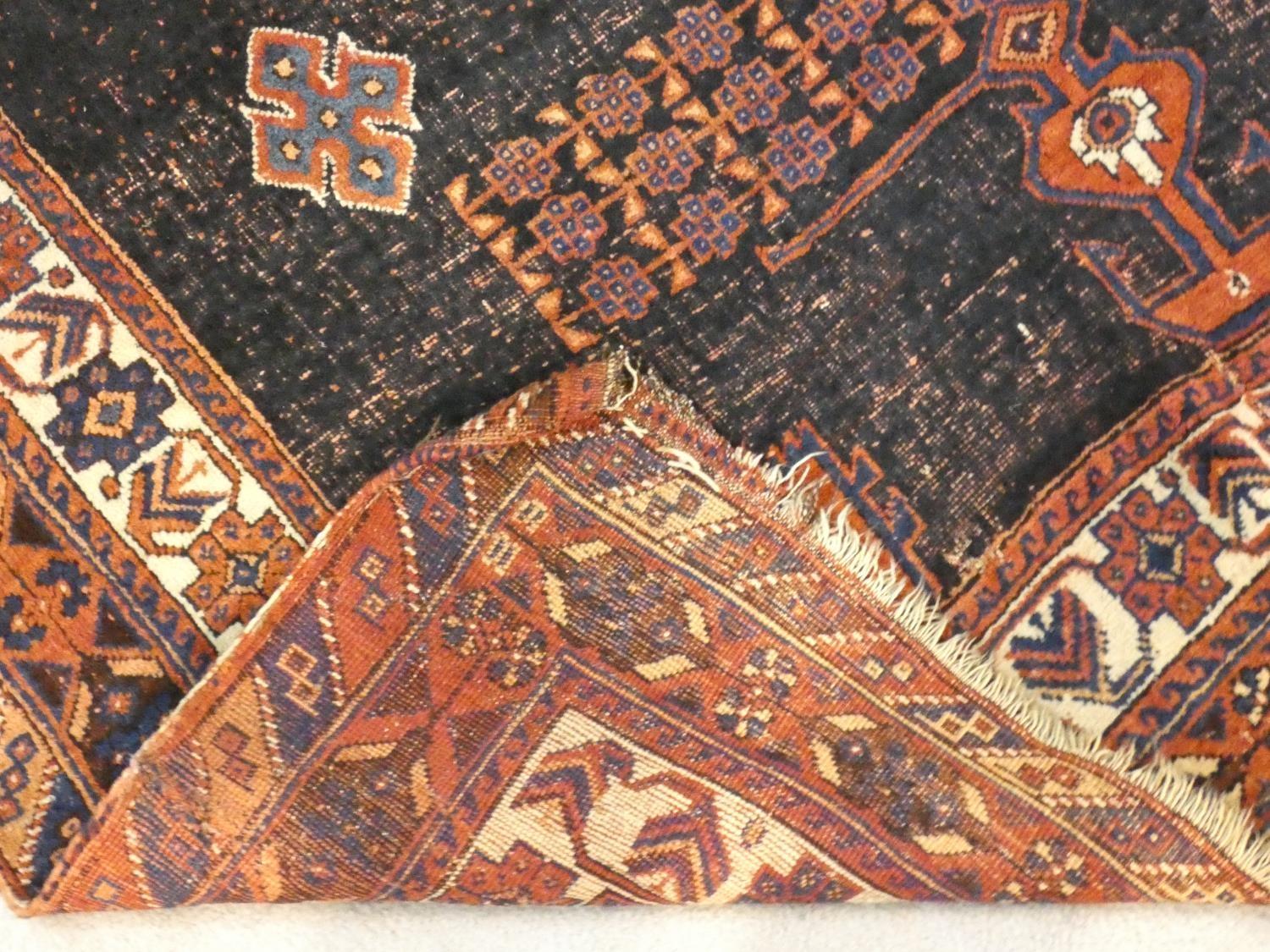 A Shirvan rug with central burgundy pole medallion on a midnight ground within stylised floral - Image 4 of 4