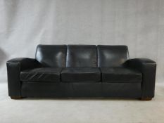 A contemporary three seater sofa in vintage style upholstered in midnight blue, from The Conran