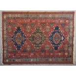 A Sumak Kilim with repeating pendant medallions on maroon ground surrounded by stylised floral and