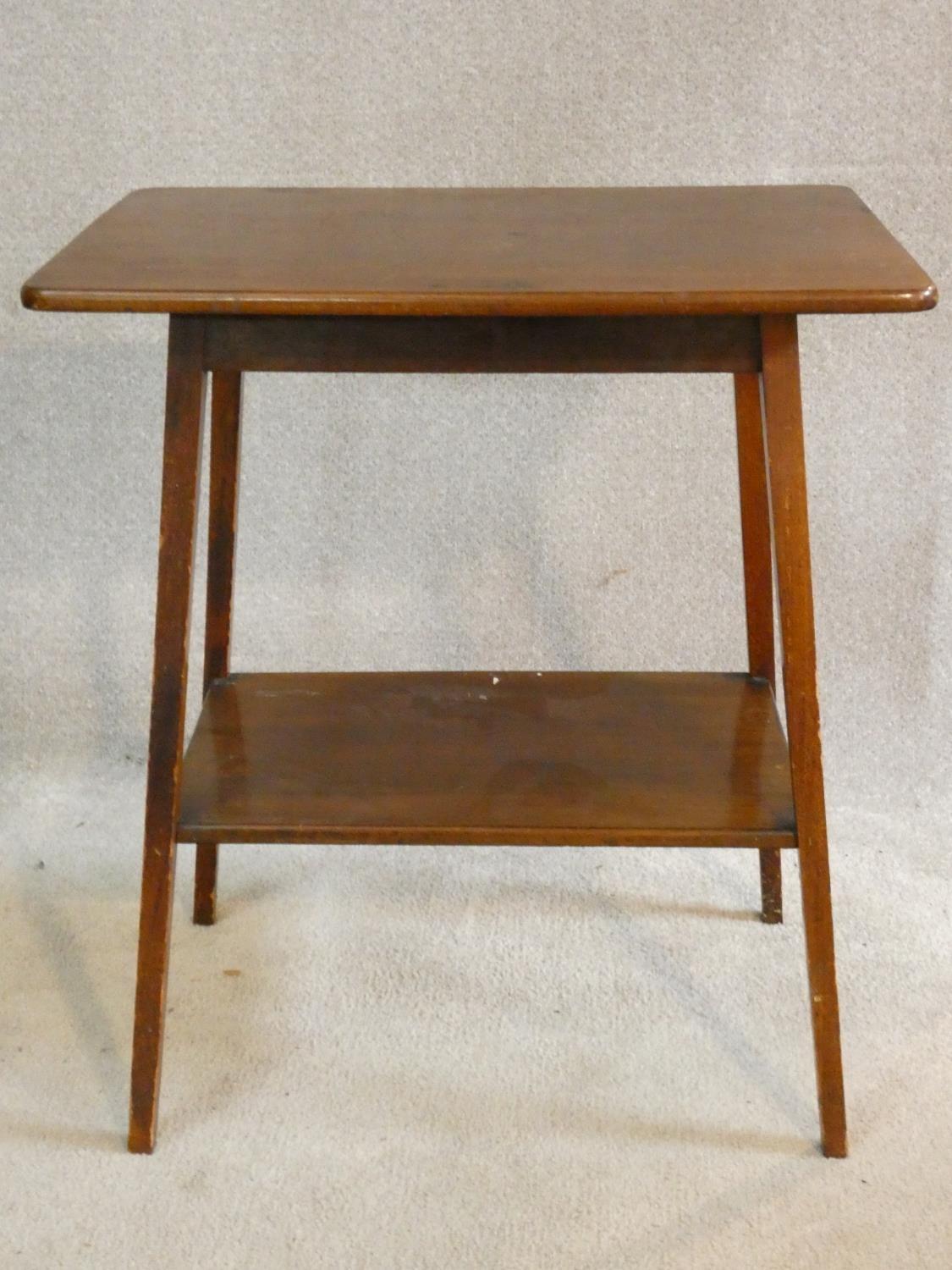 An Edwardian mahogany occasional table with splayed square tapering supports united by undertier.