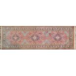 A Persian part silk runner with repeating triple medallions and scrolling floral decoration on a