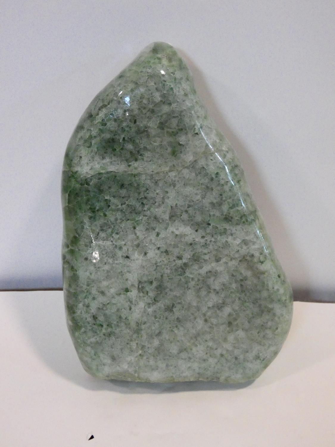 A large polished green stone crystal boulder. L.31cm