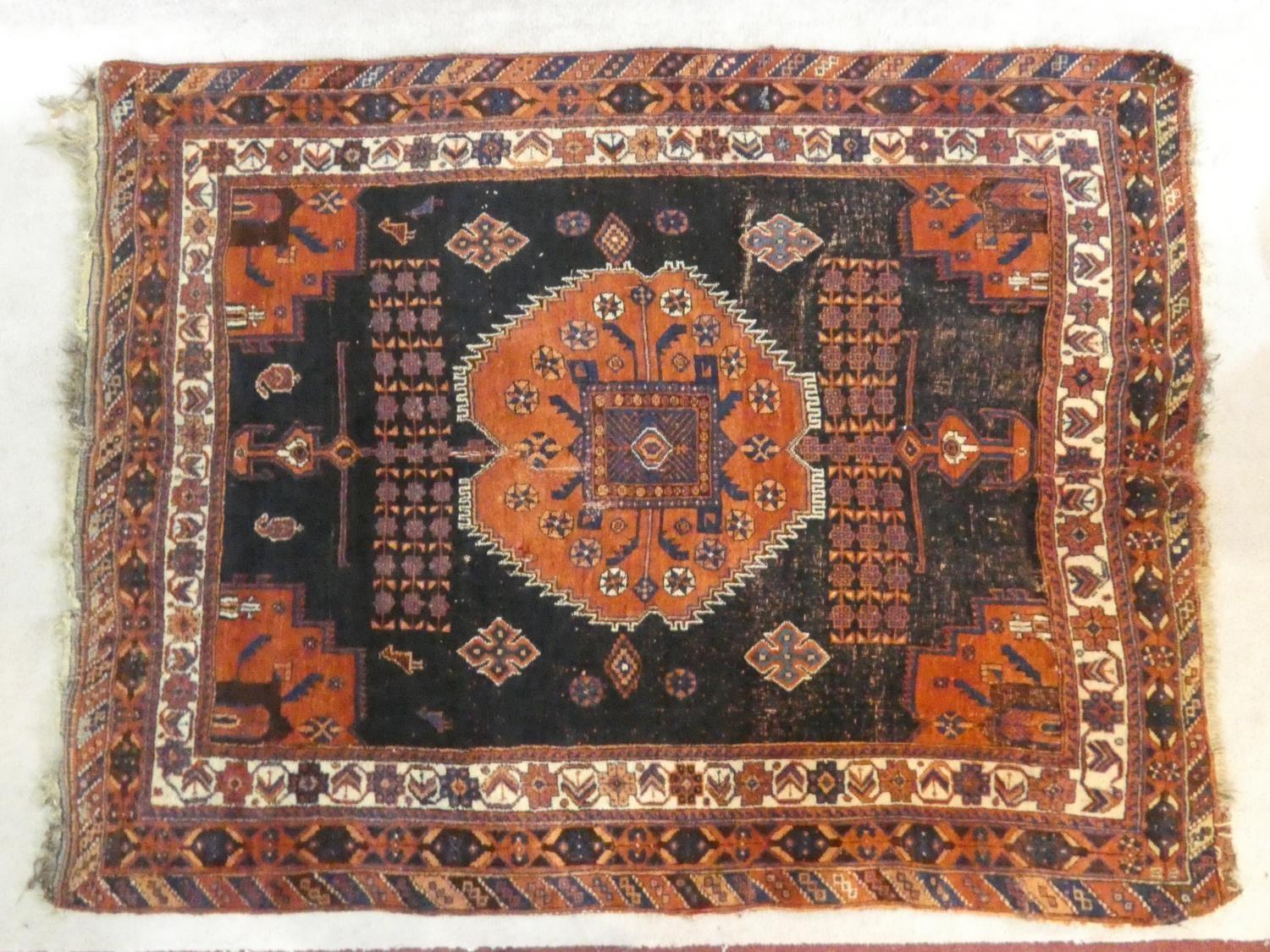 A Shirvan rug with central burgundy pole medallion on a midnight ground within stylised floral