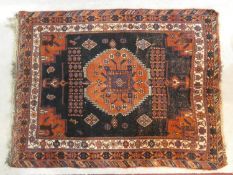 A Shirvan rug with central burgundy pole medallion on a midnight ground within stylised floral