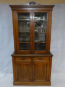 A 19th century walnut library bookcase, the upper glazed section enclosing shelves above base fitted