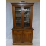 A 19th century walnut library bookcase, the upper glazed section enclosing shelves above base fitted