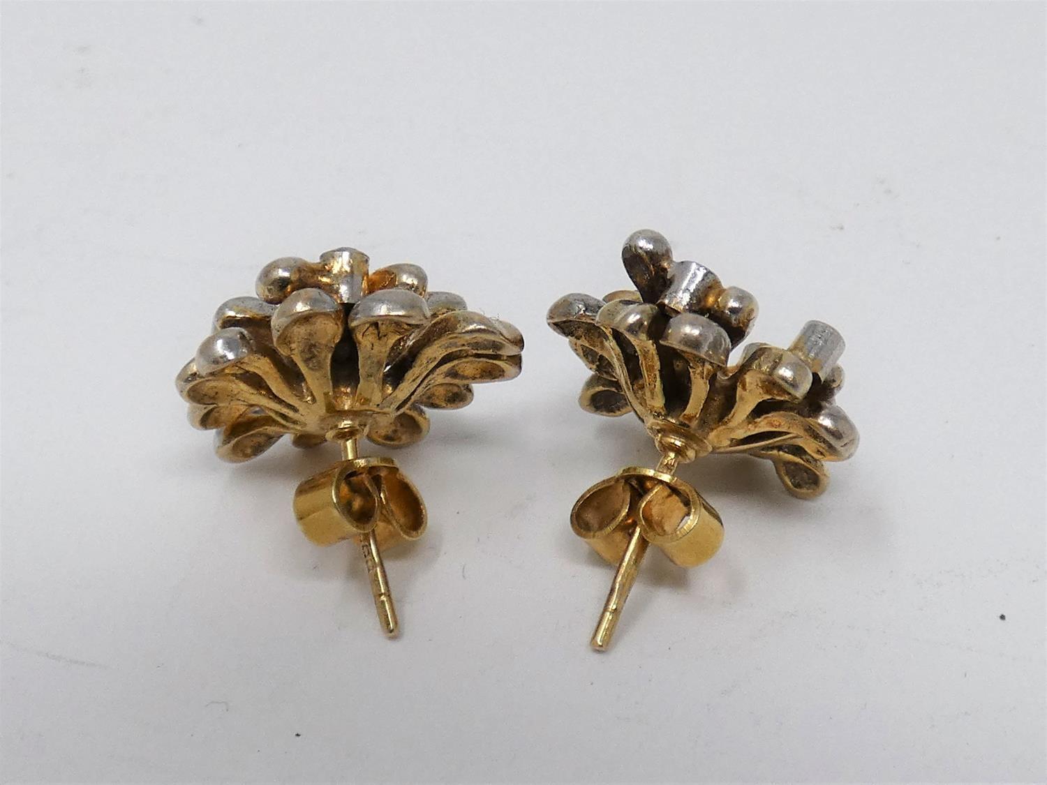 A pair of 9ct yellow and white gold and diamond stylised floral stud earrings. Each earring is set - Image 2 of 5