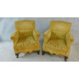 A pair of Georgian style armchairs in gold cut floral upholstery on walnut carved cabriole supports.