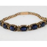 A vintage 9 ct yellow gold, sapphire and diamond articulated line bracelet. Set with seven oval