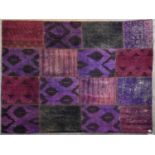 A flat weave rug with patchwork design in various magenta hues. L.237x175cm