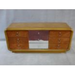 A 1970's vintage mirrored and teak chest in the Art Deco style fitted with nine drawers. H.76xW.