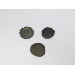 Three ancient bronze coins. One with profile of an Emperor with wreath around his head one side