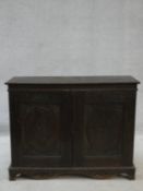 An antique country oak hall cupboard with a pair of carved panel doors on bracket feet. H.64 W.82