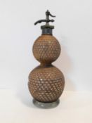 A vintage double gourd shaped blown glass wicker bound soda syphon stamped and patented by the