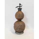 A vintage double gourd shaped blown glass wicker bound soda syphon stamped and patented by the