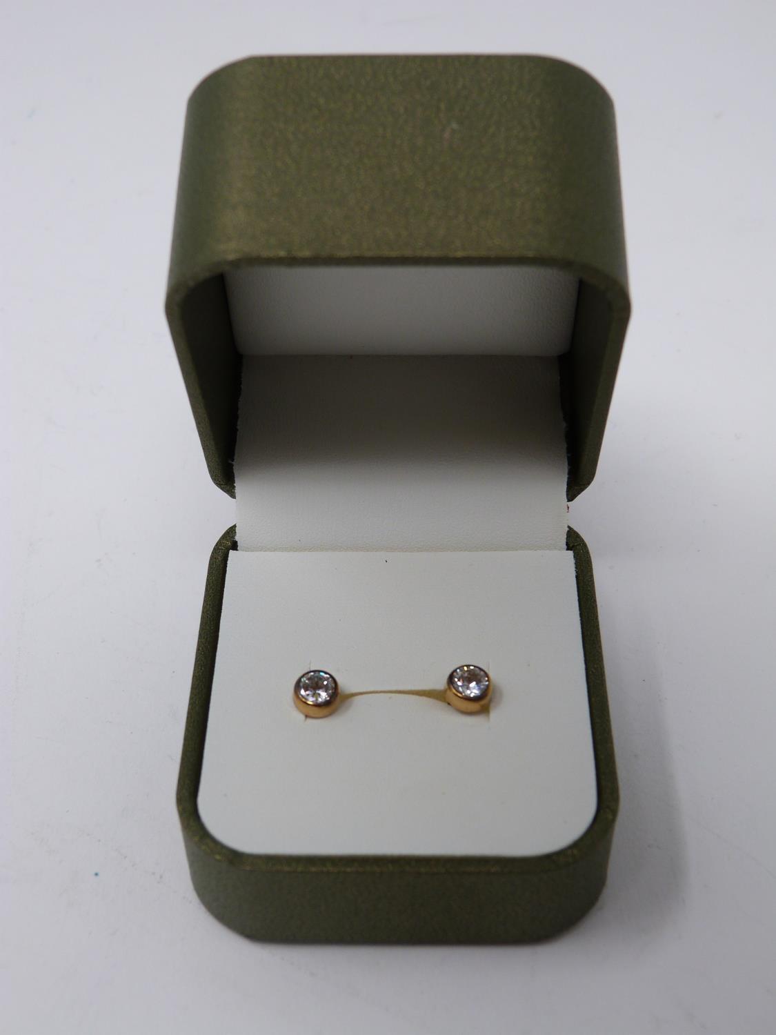 A pair of boxed 9ct yellow gold and cubic zirconia stud earrings. Posts and butterflies stamped 375.