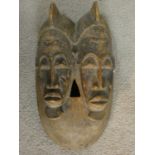 A carved hardwood Baule 'Twin Face Mask' from the Ivory Coast 37x20cm