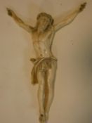 An antique carved ivory crucifix, intricately detailed, with Christ wearing a crown of thorns. H.