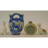 A collection of antique ceramic items. Including a blue and white Delft twin spout jug with cow