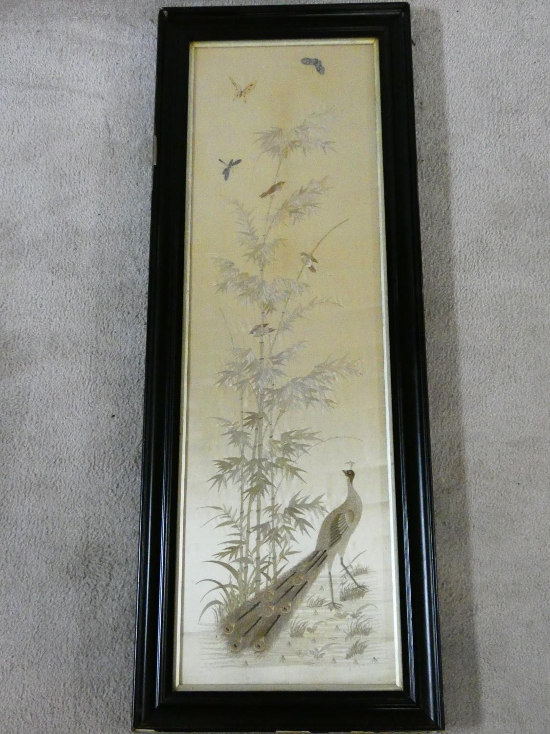 A late 19th century framed and glazed Chinese silk embroidery of a peacock with birds, butterflies