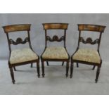 A set of three William IV mahogany dining chairs with figured veneer backrails and acanthus palmette