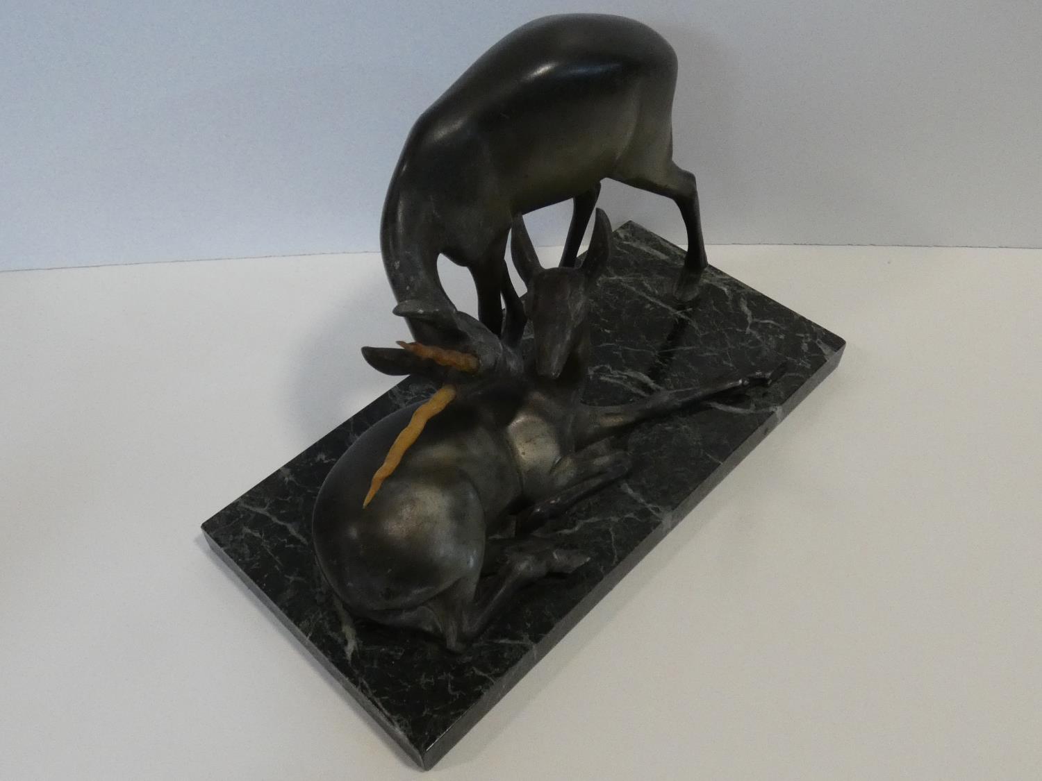 A pair of spelter Art Deco male and female gazelles mounted on a black and white veined marble base. - Image 7 of 7
