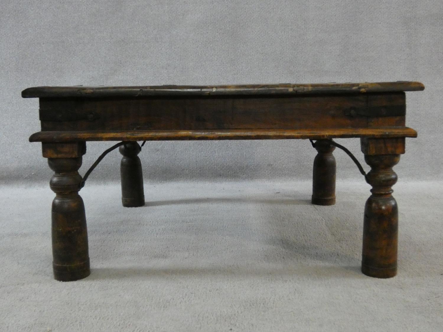 An Indian iron bound hardwood low table on circular section supports. H.42xW.80xL.80cm - Image 2 of 9