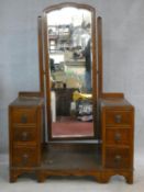 A mid century vintage oak twin pedestal dressing table fitted with central swing cheval mirror