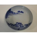 A Meji period blue and white ceramic Japanese bowl with hand painted village scene with mountains in